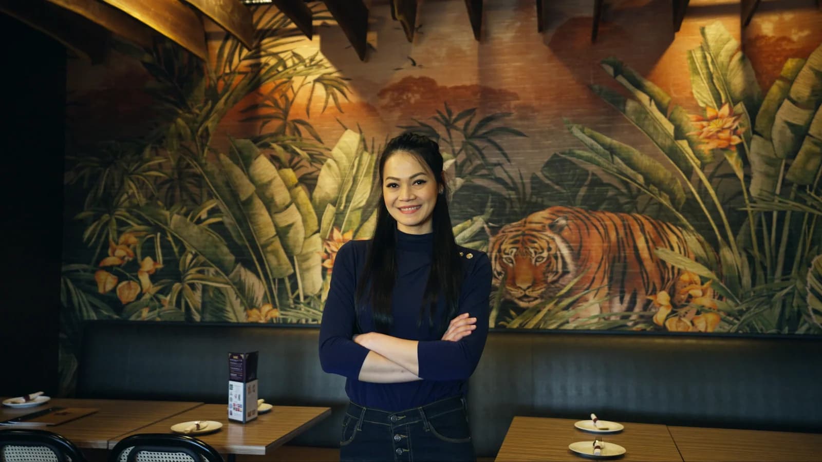 Maya in the dining room, in front of the tiger mural